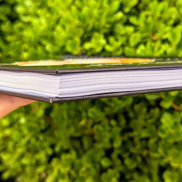 A sideview of a Milky Tomato notebook, showcasing the thickness of the book and the hardbound covers.